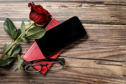 Flat lay view of a red notebook, smartphone, pen on a wooden background. Top Foto stock