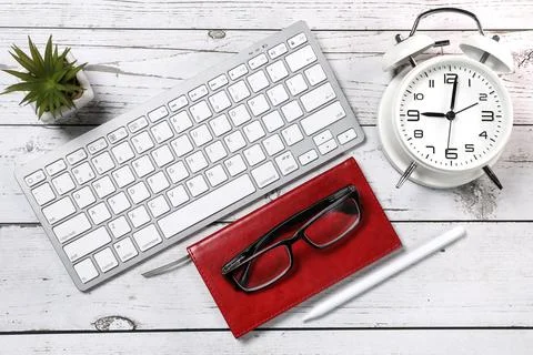Flat lay view of a red notebook, white keyboard, pen and black glasses on a Stock Photos