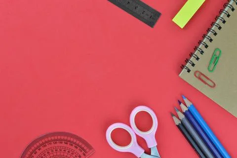 Flat lay view of stationery tools over red background with copy space. Stock Photos