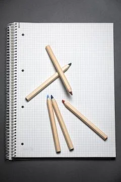 Flat lay view of white notebook, color pencils on a table. Stock Photos