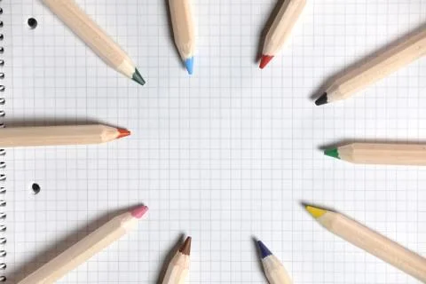 Flat lay view of white notebook , color pencils on a table. Stock Photos