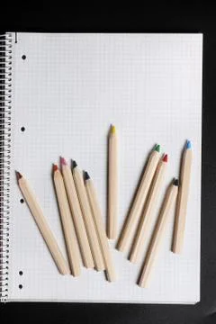 Flat lay view of white notebook , color pencils on a table. Stock Photos