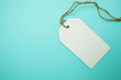 Flat lay White Blank Tag on blue background Stock Photos