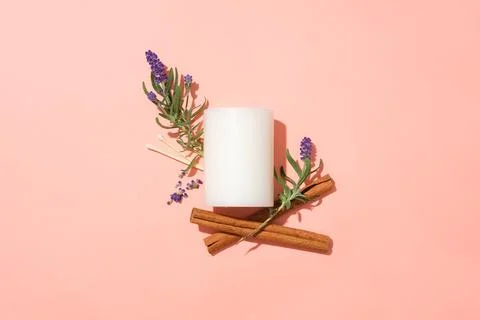 Flat lay of a white candle with lavender and cinnamon flowers on a pink bac.. Stock Photos