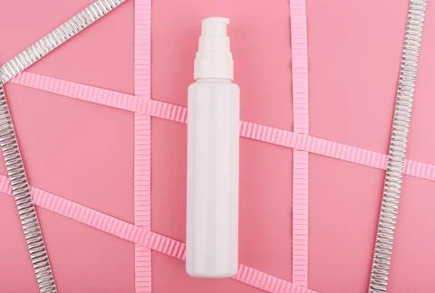 Flat lay with white glossy cream tube on bright pink background decorated with Stock Photos