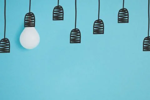 Flat lay with white light bulb pretending hanging on string isolated on blue Foto stock