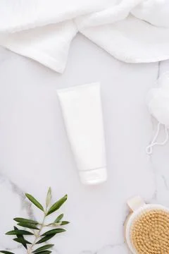 Flat lay of white plastic bottle without label, wooden brush, sponge for body Stock Photos