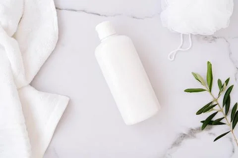 Flat lay of white plastic bottle without label, sponge for body, towel and .. Stock Photos