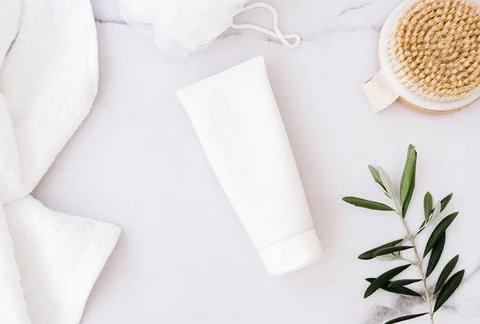 Flat lay of white plastic bottle without label, wooden brush, sponge for body Stock Photos