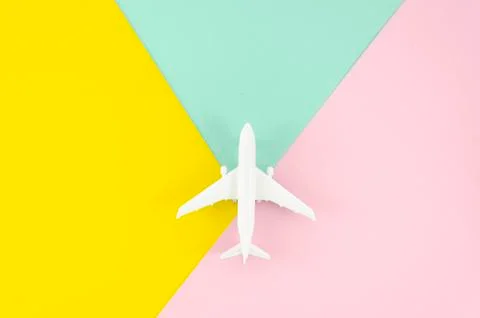 Flat lay white toy plane on yellow and light pink pop background Stock Photos