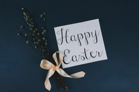 Flat lay of willow branches and Happy Ester greeting card isolated on blue Stock Photos