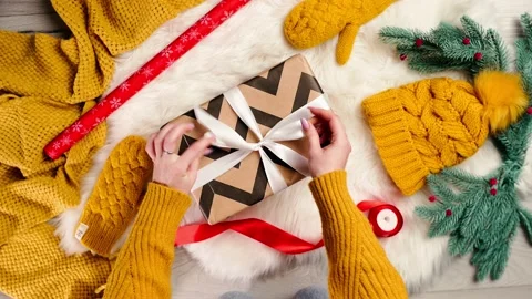 Flat Lay. Women's Hands Adjust the Bow on the Gift Box. A Gift for Christmas and Stock Footage 220273618