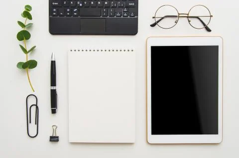 Flat lay work place. White office desk table with laptop, clips, glasses Stock Photos
