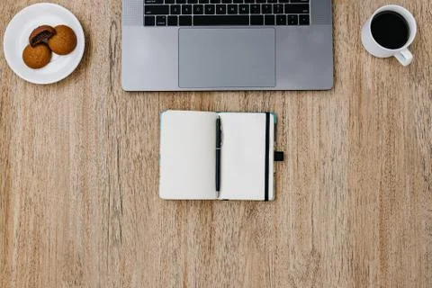 Flat lay of workplace. Freelance work laptop smartphone and note pad. Morning Stock Photos