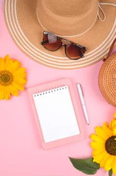 Flat lay of workspace desk, notepad and sunflower on pink background Stock Photos