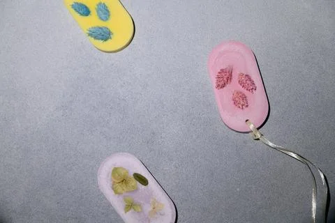Flat lay Yellow, Pink and Lilac Oval Wax Aroma Sachet with Handmade Dried Flo Stock Photos