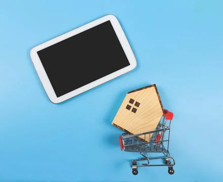Flat layout of blank black screen tablet and  wooden house model in shopping  Stock Photos