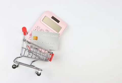 Flat layout of calculator and creddit card in Shopping trolley  on white  bac Stock Photos