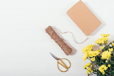 Flat layout gift box next to bouquet of yellow flowers Stock Photos