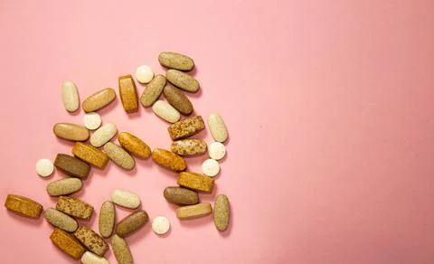 Flat layout of white capsule pills on a pink background Stock Photos