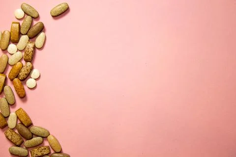 Flat layout of white capsule pills on a pink background Stock Photos