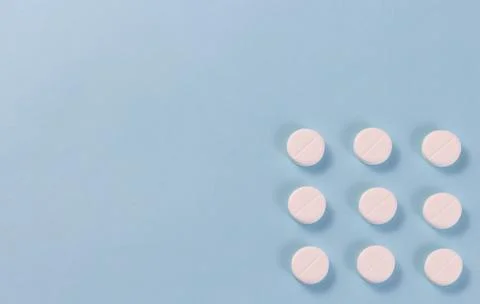 Flat layout white pills arranged in a row isolated on a blue background.copys Stock Photos