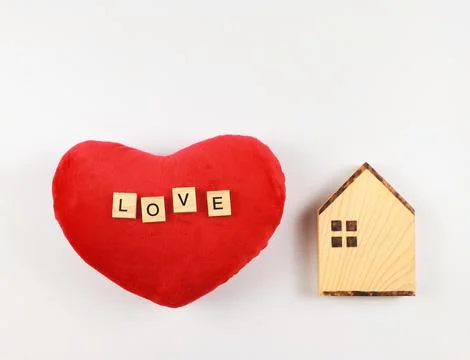 Flat layout of wooden model house and red heart shape pillow with wooden le.. Stock Photos