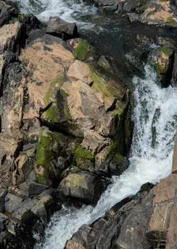 Flat light image of waterfall curving through the frame and moss on the rocks Foto stock