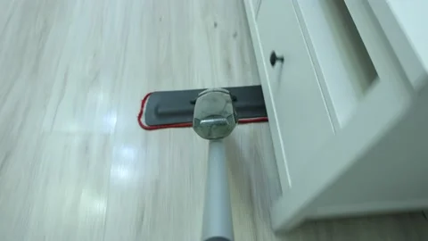 Flat mop with spray and microfiber pad is used for wet cleaning in living room. Stock Footage 149531461