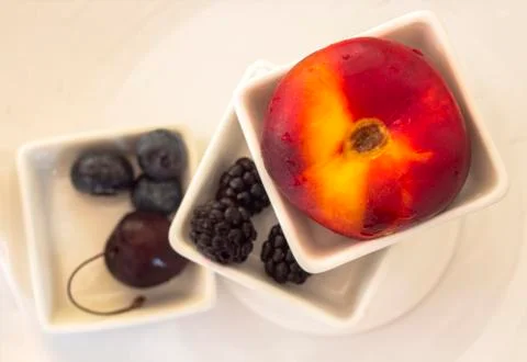 Flat nectarine, cherry, blueberries, and blackberries. Stock Photos