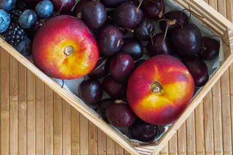 Flat nectarines, cherries, blueberries, and blackberries. Stock Photos