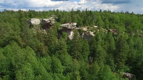 Flat peak of large stones over  tops of spruce Vidéo 74232107