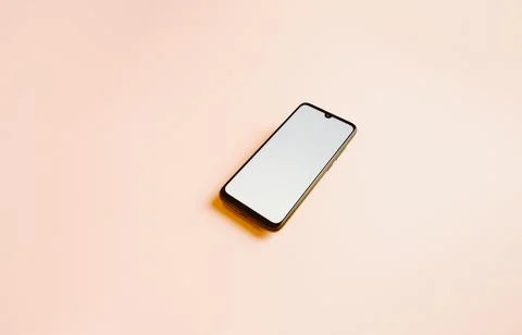 Flat pink background with a mobile phone with a white screen and copy space.. Stock Photos