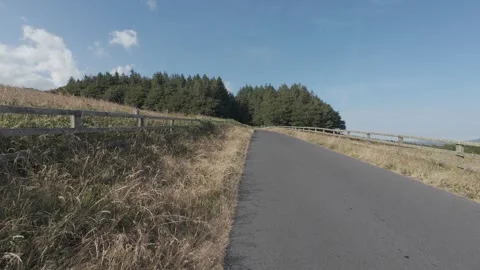 Flat profile empty country road leading through green hills Stock Footage 340444668