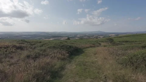 Flat profile hiker dirt trail on grassy hill with valley view Stock Footage 340445177
