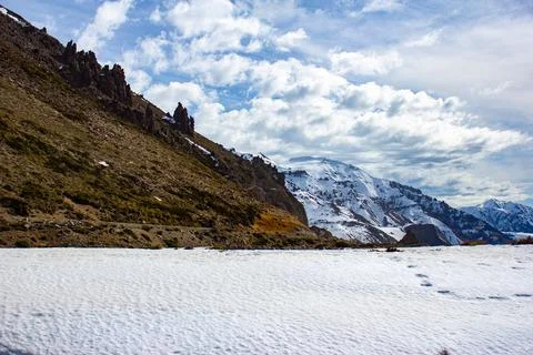 Flat road full of snow near the Andes mountain range Stock Photos
