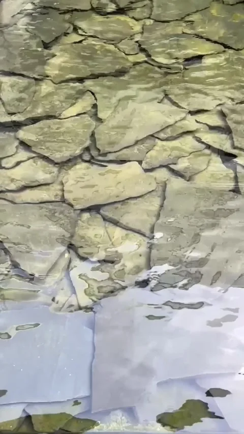 Flat rocks under clear water with ripples and reflections Stock Footage 318711848