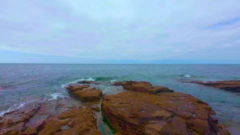 Flat Rocky Ledges with Ocean Waves at Coast Stock Photos