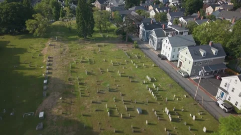 Flat roofed brick school building sits beside historic cemetery with scattered Stock Footage 341675828