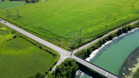 Flat rural plot of land with corn farm along river with power lines, aerial Vídeos de archivo 210385677