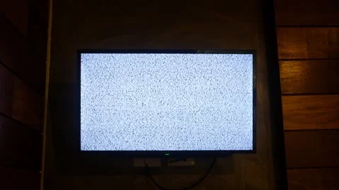 Flat screen TV displaying white noise static mounted on wooden wall Stock Footage 340525999