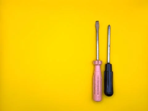 A flat screwdriver on isolated yellow background. Flat lay. Top view, copy space Stock Photos