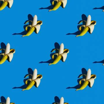 Flat seamless pattern of peeled bananas on a blue background Stock Photos