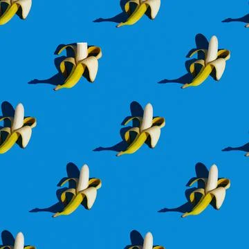 Flat seamless pattern of peeled bananas on a blue background Stock Photos