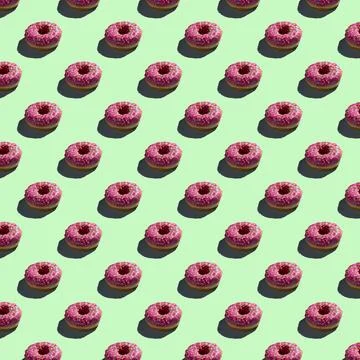 Flat seamless pattern of pink donuts on a warm background Stock Photos