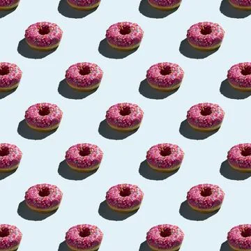 Flat seamless pattern of pink donuts on a warm background Stock Photos