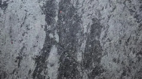 The flat surface of a roughly worked black natural stone with veins of white Stock Photos