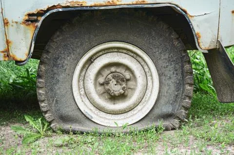 Flat tire on an old rusty SUV close-up. Stock Photos