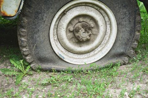 Flat tire on an old rusty SUV close-up. Stock Photos