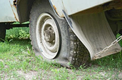 Flat tire on an old rusty SUV close-up. Stock Photos